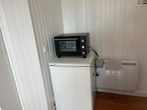 a microwave sitting on top of a refrigerator at Studio - Port Ferry Ouitreham in Ouistreham