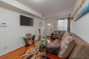 a living room with a couch and a table at Charming Townhouse Sleeps 7 With Private terrace Garden in Baltimore