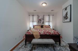 a bedroom with a bed with a red bedspread at Charming Townhouse Sleeps 7 With Private terrace Garden in Baltimore