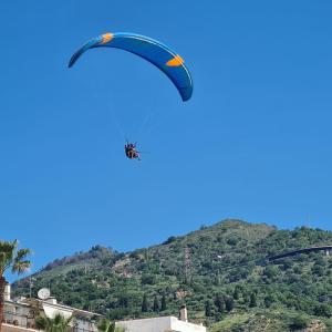 Ein Drachen fliegt über einen Berg in der Unterkunft Terrazza Fiumara in Letojanni