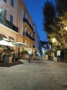 a couple of people walking down a city street at Elegant 2 pièces au coeur du Cannet historique in Le Cannet