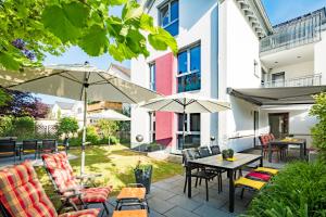 a patio with tables and chairs and umbrellas at Design-Apartments by Ulrike Horster in Bensheim