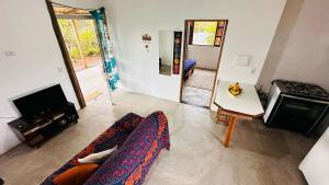 a living room with a couch and a stove at Refúgio do Boto, casa nova em meio a natureza rústica in Alto Paraíso de Goiás