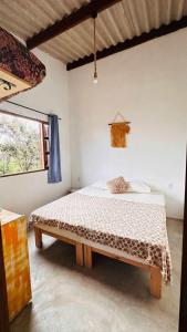 a bedroom with a bed in a room with a window at Refúgio do Boto, casa nova em meio a natureza rústica in Alto Paraíso de Goiás