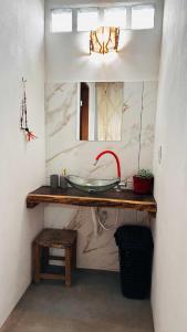a bathroom with a sink and a mirror at Refúgio do Boto, casa nova em meio a natureza rústica in Alto Paraíso de Goiás +24 photos
