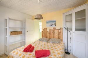 a bedroom with a bed with red pillows on it at Charmante maison vendéenne proche de la plage in Notre-Dame-de-Monts