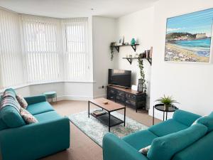 スランディドノにあるPrivate Parking, Central Llandudno, King Bed with Ensuite at Clement Lodgeの青いソファ2つとテレビのあるリビングルーム +22枚の写真