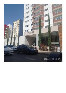 a parking lot with cars parked in front of a building at CONDOMÍNIO EVEREST-Flat em Caldas Novas-GO in Caldas Novas