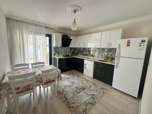 a kitchen with a table and a white refrigerator at Villa huzur in Marmaris
