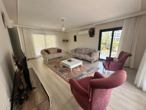 a living room with a couch and chairs and a tv at Villa huzur in Marmaris