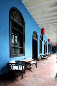 a blue wall with tables and benches in a building at Cheong Fatt Tze - The Blue Mansion in George Town