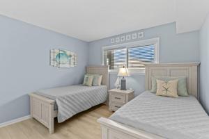 a bedroom with two beds and a window at Cast a Waves. Condo with partial Atlantic views and a POOL in Carolina Beach +28 photos