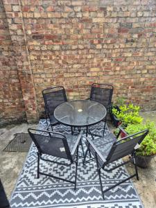 a table and two chairs and a brick wall at Lovely Cosy Two Bed Home,Peak District Gateway in Buxton