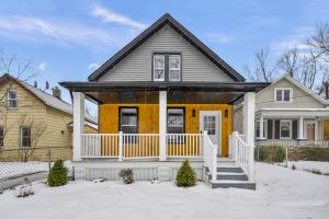 a house with a porch and yellow at Beautiful Tremont Jewel in Central Cleveland location in Cleveland