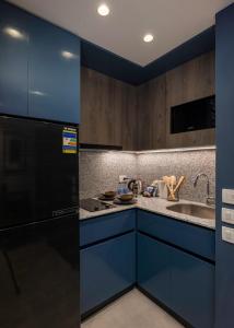 a blue kitchen with a sink and a refrigerator at Exclusive savings at 22 by spacey #43 Studio in Maadi in Cairo