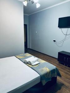 een slaapkamer met een bed met handdoeken erop bij Ак сункар in Zhezdi