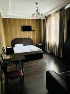 een slaapkamer met een bed, een tafel en een stoel bij Ак сункар in Zhezdi