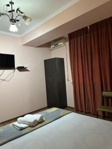 een slaapkamer met een bed en een zwarte kast bij Ак сункар in Zhezdi