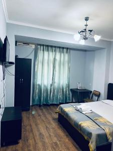 een slaapkamer met een bed en een raam met een dressoir bij Ак сункар in Zhezdi