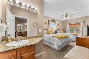 a bedroom with two beds and a sink and a mirror at Golf View Luxe at Stonebridge in Branson West