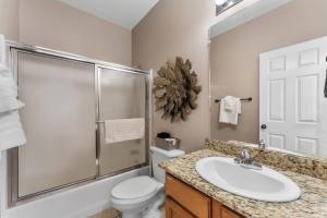 a bathroom with a sink and a toilet and a shower at Golf View Luxe at Stonebridge in Branson West +41 photos