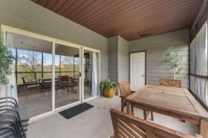 a screened porch with a table and a dining room at Golf View Luxe at Stonebridge in Branson West