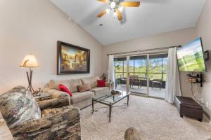 a living room with a couch and a table at Golf View Luxe at Stonebridge in Branson West