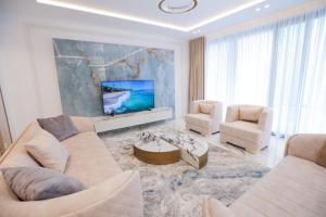 a living room with two couches and a tv at Palmera Vip Villa in Sarandë