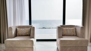 two chairs sitting in front of a large window at Palmera Vip Villa in Sarandë +6 photos