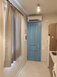 a blue door in a kitchen next to a refrigerator at Andros Guesthouses in Andros