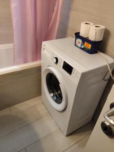 a washing machine with a box of toilet paper on it at Andros Guesthouses in Andros