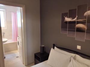 a bedroom with a bed and a bathroom at Andros Guesthouses in Andros