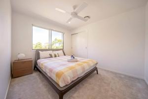 a bedroom with a bed with a ceiling fan at Waterfront Wonderland - Luxury Canal Front Villa w Pool in Gold Coast +26 photos