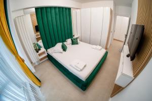 a small bedroom with a bed with a green curtain at Sim Seaside Odyssey in Mamaia Sat/Năvodari +68 photos