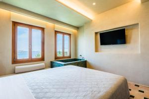 a bedroom with a bed and a flat screen tv at AG town suites in Megali Ammos +24 photos