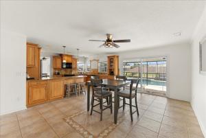 Una cocina y un comedor con mesa y sillas. en Elegant Canal Front Oasis w Pool Near Beaches, en Palm Coast