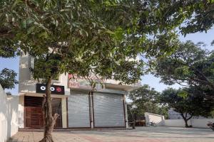 Hotel O Hira Royal Palace And Lawn في لاكناو: مبنى فيه باب جراج وشجرة