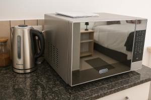 a microwave oven sitting on a counter with a coffee maker at La Roca Self Catering & Accommodation in Lüderitz