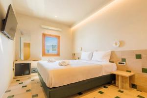 a bedroom with a large bed and a tv at AG town suites in Megali Ammos