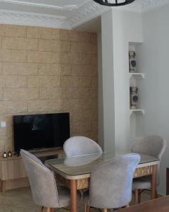 a dining room with a table and chairs and a tv at Apartamentos de Fola 3 in Asilah