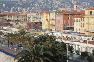 a city with buildings and palm trees and a street at Hotel Suisse in Nice