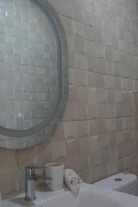 a bathroom with a sink and a mirror and a toilet at Apartamentos de Fola 3 in Asilah