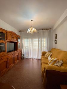a living room with a couch and a television at Brisa y Mar in Punta Umbría
