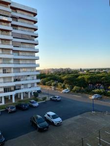 a parking lot with cars parked in front of a building at Brisa y Mar in Punta Umbría