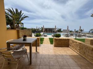 a patio with a table and chairs and a pool at Pachia Ammos Falasarna in Falasarna
