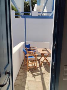 a balcony with two chairs and a table at Andros Guesthouses in Andros