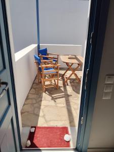 a door open to a patio with a table and chairs at Andros Guesthouses in Andros