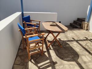 two chairs and a table and a table and chairs at Andros Guesthouses in Andros