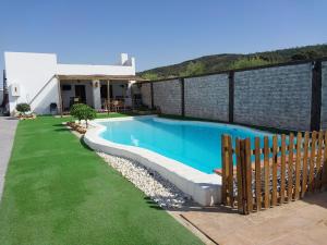 a swimming pool in a yard next to a house at Chalet rural a las afueras de Montellano in Montellano