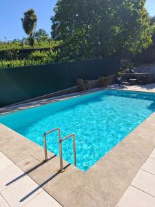 a swimming pool with blue water in a yard at HOUSE DOURO in Peso da Régua